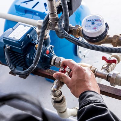 Technician checking water system nodes to help reduce water risk and cost.