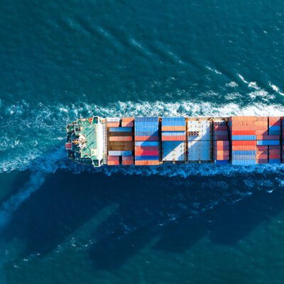 Aerial top view of cargo ship carrying container and running for export goods from cargo yard port to custom ocean concept technology transportation , customs clearance.